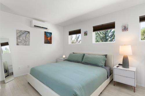 a white bedroom with a bed and windows at Amethyst Retreat. Back Yard with Hot Tub & Views! in Sedona