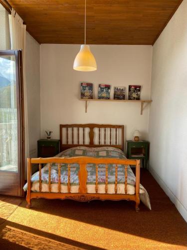 une chambre avec un lit en bois dans une pièce dans l'établissement Repos, Cité Vauban., à Briançon