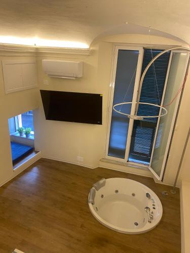 a bathroom with a large tub in a room with two windows at Due Papi in Savona