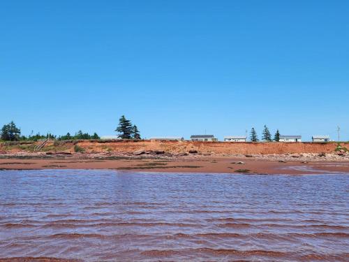 a body of water with a beach in the background at Cottages On PEI-Oceanfront in Bedeque