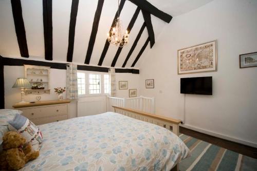 a bedroom with a large bed and a television at Daisy Cottage in Warwick
