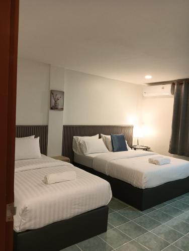 a hotel room with two beds in a room at Matinee House Hatyai in Hat Yai