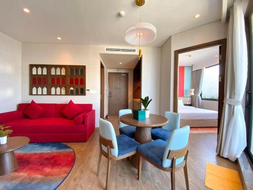 a living room with a red couch and a table at APEC Mandala - căn hộ in Ấp Thiẹn Ái