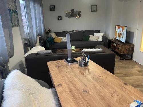 a living room with a table and a couch at Chez Suzi - Appartement entièrement rénové in Niederbronn