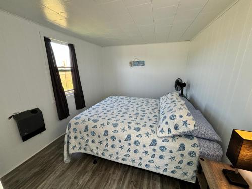 a small bedroom with a bed and a window at Cottages On PEI-Oceanfront in Bedeque