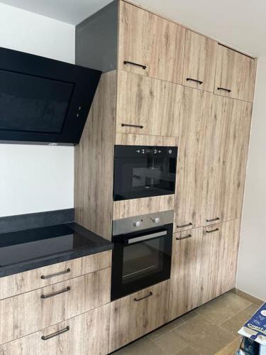 - une cuisine avec des placards en bois, un four et un four micro-ondes dans l'établissement Maison Clémentine, à Cros-de-Cagnes