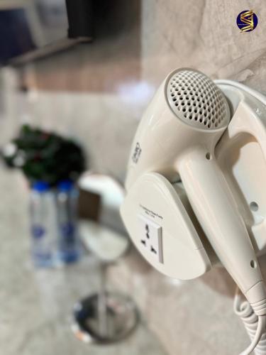 a hair dryer on the wall of a bathroom at S1 City Hotel Buriram in Buriram