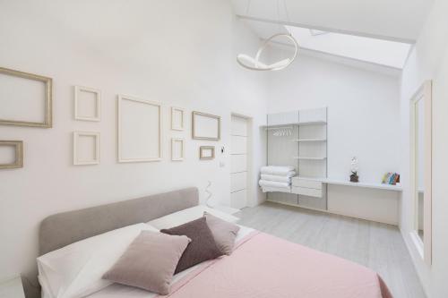 Un dormitorio con paredes blancas y una cama con sábanas rosas. en Sweethome Gries - Con Garage, en Bolzano