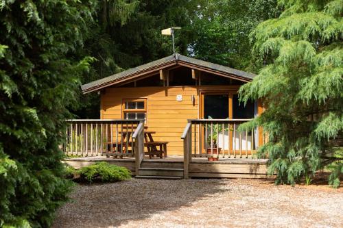 a wooden cabin with a porch and a deck at Wensleydale Lodges in Masham