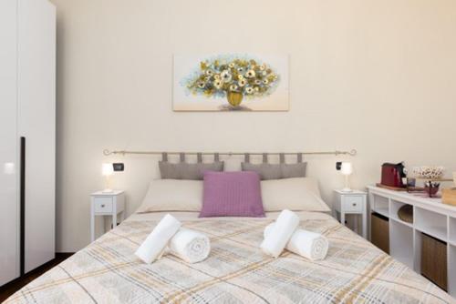 a white bedroom with a large bed with pillows at Casa Sancarlino - 200mt Clinica Zucchi in Monza