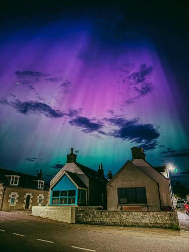 an aurora in the sky above a house at Victoria Hotel in Portknockie