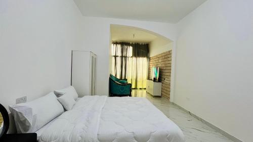 a white bedroom with a large white bed in it at AD Villa Studio in Abu Dhabi