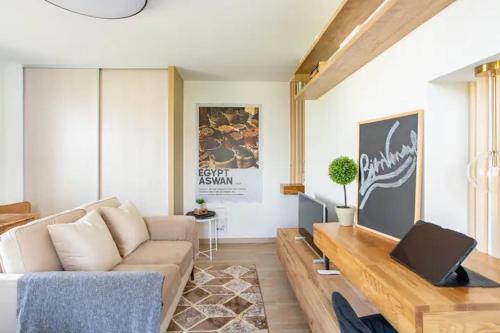 a living room with a couch and a table at Le studio Parisien in Boissy-Saint-Léger