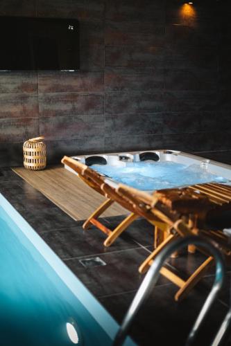 a hot tub in a room with a table and chairs at Pod Vojtěchem - soukromý wellness apartmán in Wotitz