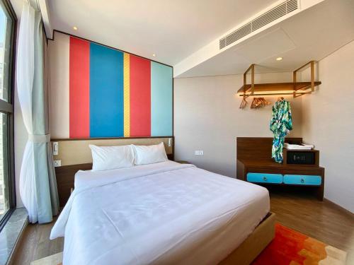 a bedroom with a large bed and a colorful wall at APEC Mandala - căn hộ in Ấp Thiẹn Ái