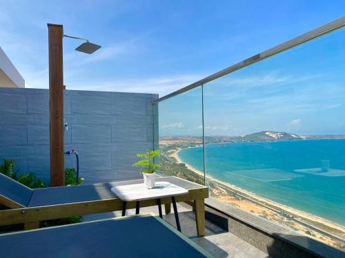 a balcony with a table and a view of the ocean at APEC Mandala - căn hộ in Ấp Thiẹn Ái