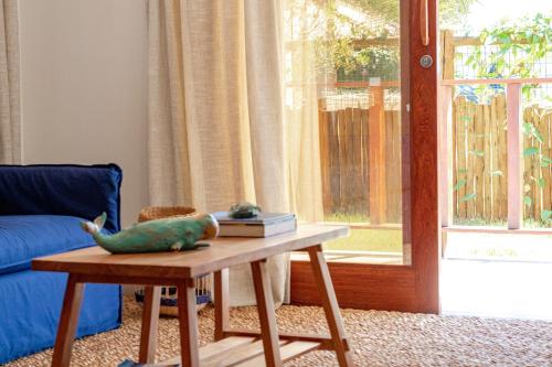 a living room with a table and a blue couch at Bahia Soul - Morada Garú - Taipu de Fora - Península de Maraú in Taipu