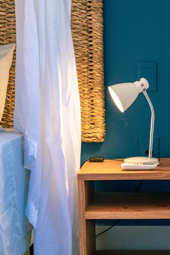 a bedroom with a bed with a lamp and a table at Bahia Soul - Morada Garú - Taipu de Fora - Península de Maraú in Taipu