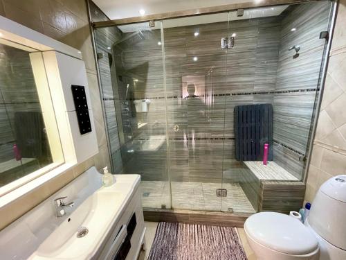 a bathroom with a shower and a toilet and a sink at Au Cœur Des Plages de Rabat in Oulad Kerroum
