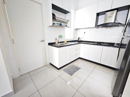 een keuken met witte kasten en een spoelbak bij Ais-Kacang Sweet Home Pinnacle Tower in Johor Bahru