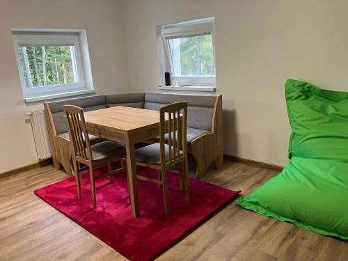 a dining room with a table and chairs and a bed at Chata u Járy in Trojanovice
