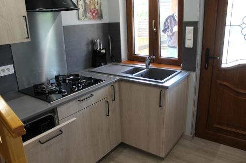 a small kitchen with a sink and a stove at Garte Hiesel la maison de jardin Piscine été 2026 in Scherwiller