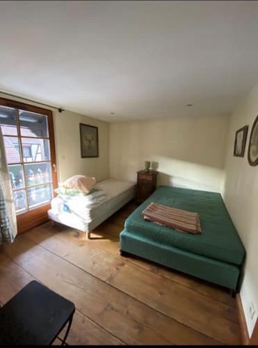 une chambre avec un lit, un canapé et une fenêtre dans l'établissement Appartement typique alsacien, à Boofzheim