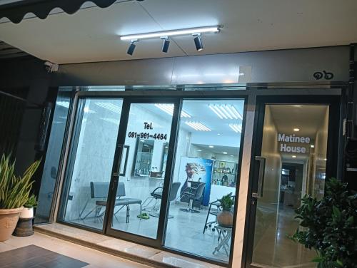 Un frente de tienda con puertas de vidrio y una ventana. en Matinee House Hatyai, en Hat Yai
