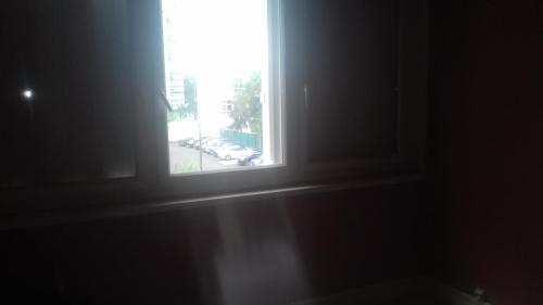 une fenêtre ouverte avec vue sur un parking dans l'établissement Daxy91, à Ris-Orangis