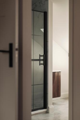 a glass door with a mirror in a room at Zurenborg Suites in Antwerp