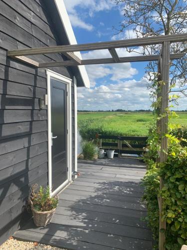a wooden porch with a door and a bench at Natuurhuisje Gouderak in Gouderak