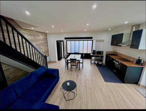a living room with a blue couch and a table at La Maison du faubourg & Spa in Vitry-le-François