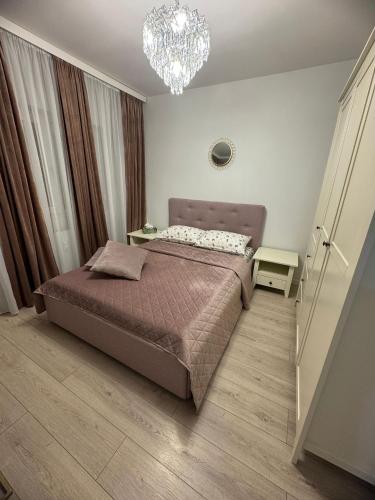 a bedroom with a bed and a chandelier at RIN HOUSe 1 in Drobeta-Turnu Severin
