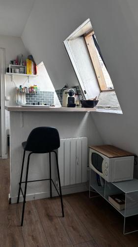 une cuisine avec un tabouret et un comptoir avec une fenêtre dans l'établissement Petit studio - PARIS 10ème arrondissement, à Paris