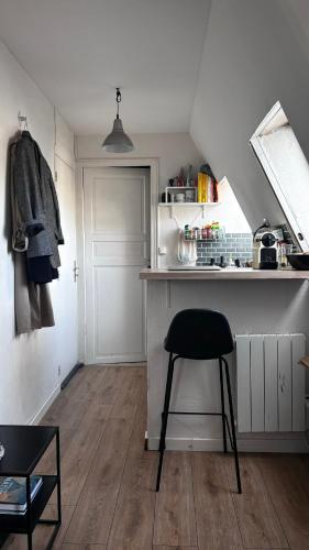 - une cuisine avec une chaise noire dans la chambre dans l'établissement Petit studio - PARIS 10ème arrondissement, à Paris