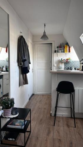 une cuisine avec une table et une chaise dans une pièce dans l'établissement Petit studio - PARIS 10ème arrondissement, à Paris