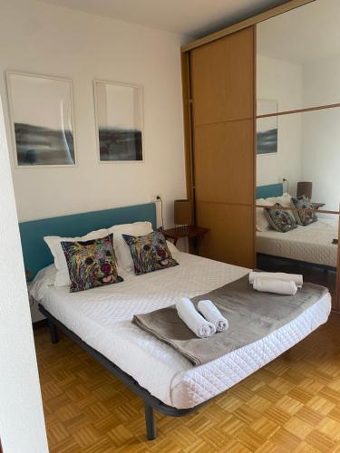 a bedroom with a bed with two towels on it at DonostiNest in Donostia-San Sebastián