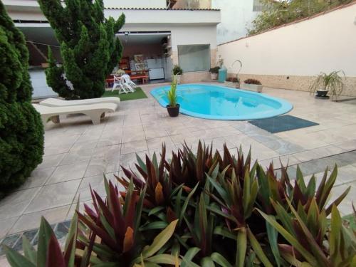 a patio with a swimming pool and some plants at Casa na Praia in Jacaraípe