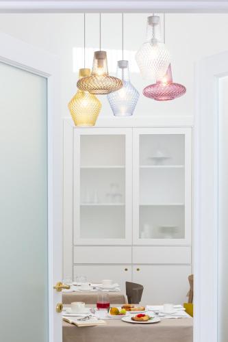 a room with several glass vases on a white cabinet at Palazzo Marini B&B di Charme in Lecce