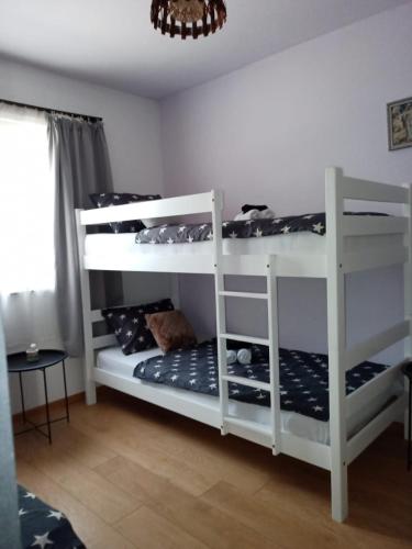 two white bunk beds in a room with a chandelier at Apartman Dane Međugorje in Međugorje
