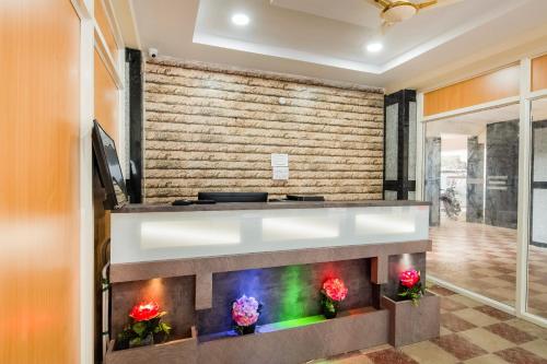 a fireplace in a living room with flowers at Super Capital O RR Towers by CJ in Vijayawāda