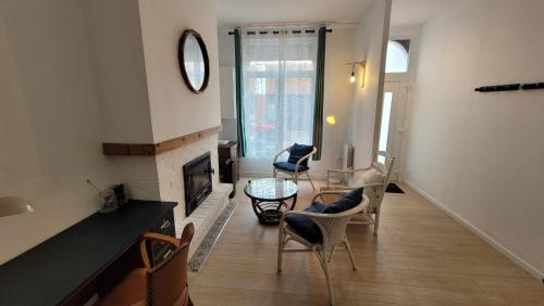 - un salon avec une cheminée et des chaises dans l'établissement Maison 8 personnes Louvre Bollaert WIFI PS4, à Lens