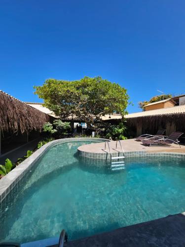 a swimming pool with blue water in a resort at Pousada Sempre Graciosa in Praia do Frances