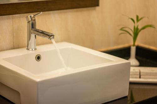 a white sink with a faucet in a bathroom at La Oasis by Meraden ,Goa in Anjuna