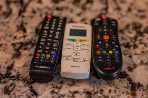 three remote controls sitting on top of a counter at La Oasis by Meraden ,Goa in Anjuna
