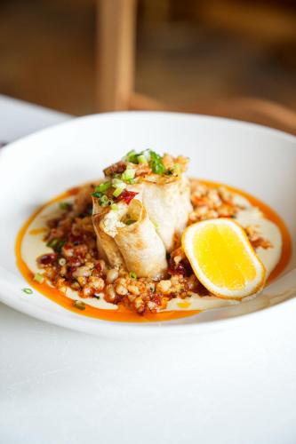 a plate of food with a piece of fish and a lemon at Unfound Door - Design Hotel in Tbilisi City
