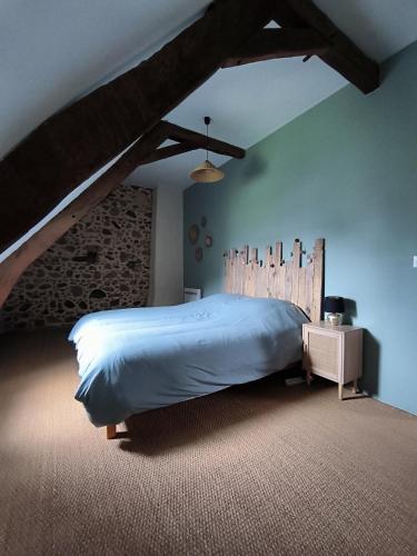 une chambre avec un grand lit avec une tête de lit en bois dans l'établissement Gite dans un village des Pyrénées, à Luc