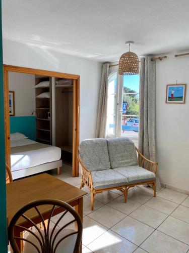 a living room with a couch and a bed and a table at Hôtel & Appart-hôtel Olatua in Bidart