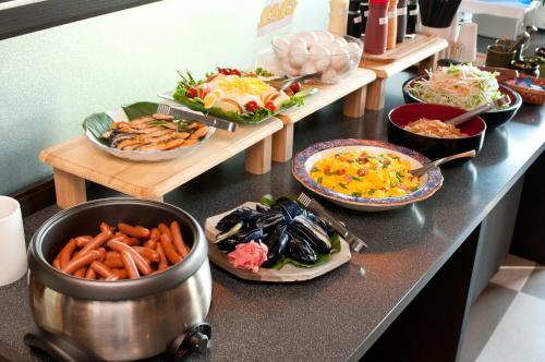 a buffet with plates of food on a counter at Super Hotel Arai Niigata in Myoko