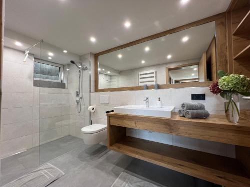 a bathroom with a sink and a toilet and a shower at Bio-Ferienhof Köpf in Rieden am Forggensee